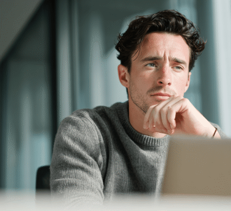 Mann arbeitet in einem Büro und schaut konzentriert auf seinen Computer