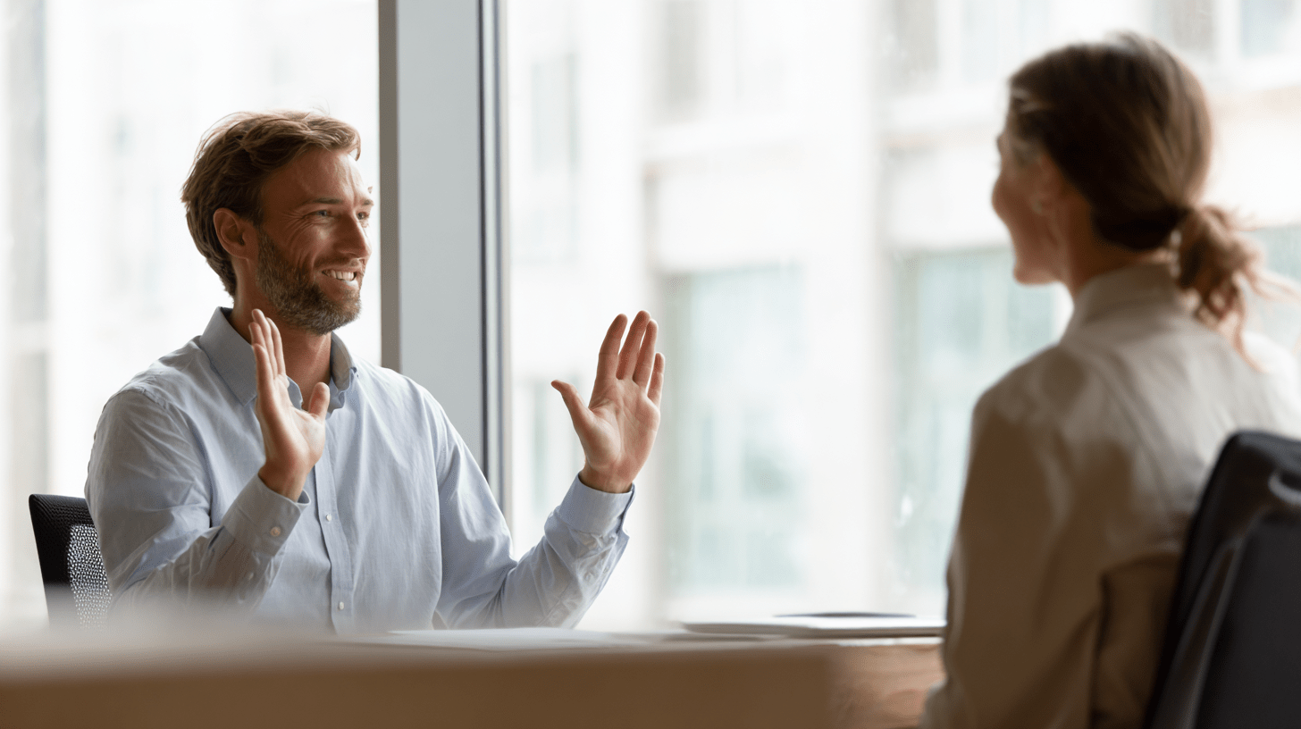 Mann sitzt im Büro einer Frau gegenüber und gestikuliert mit seinen Händen, dass er das Angebot ablehnt