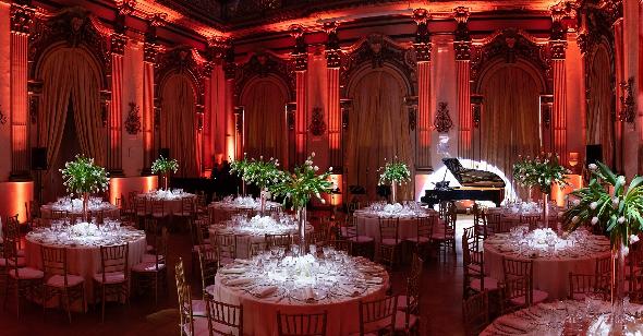 Eventlocation mit mehreren Tischen und einem Piano.