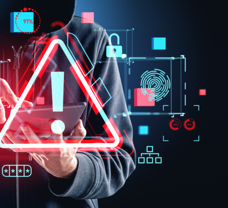 Person im dunklen Hoodie. Davor ein Hologram mit einem Vorsicht-Zeichen sowie Icons, die auf Sicherheit verweisen.