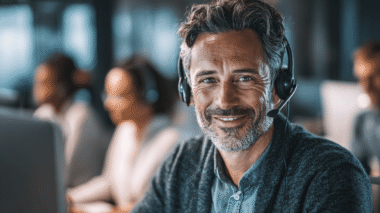 Mann, Mitte 40 mit Bart und Headset am PC, Symbolbild für Webinare